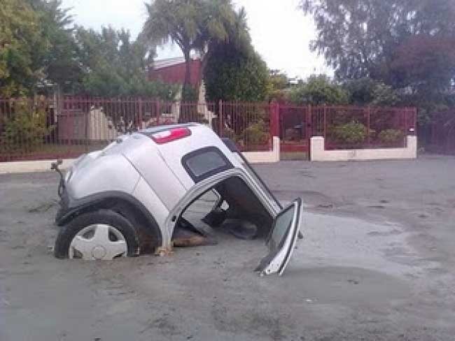 A car half submerged in the ground